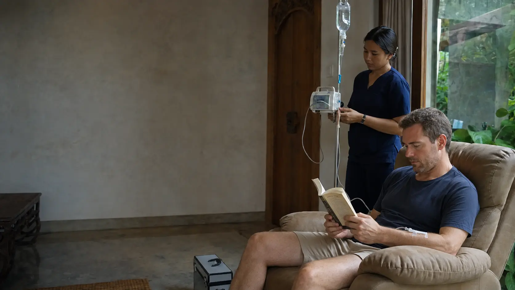 Indonesian nurse monitoring a patient during a supervised NAD+ infusion in a Bali villa